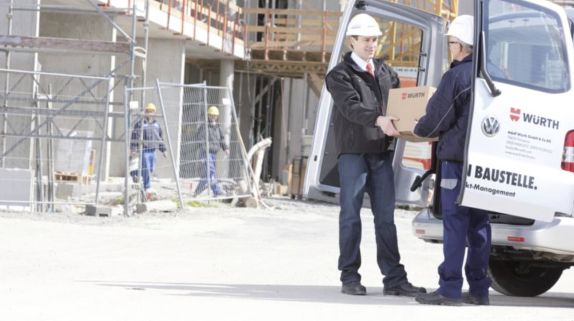 Baustellen Service Baustellen Service, Übergabe eines Würth-Pakets vor einer Baustelle