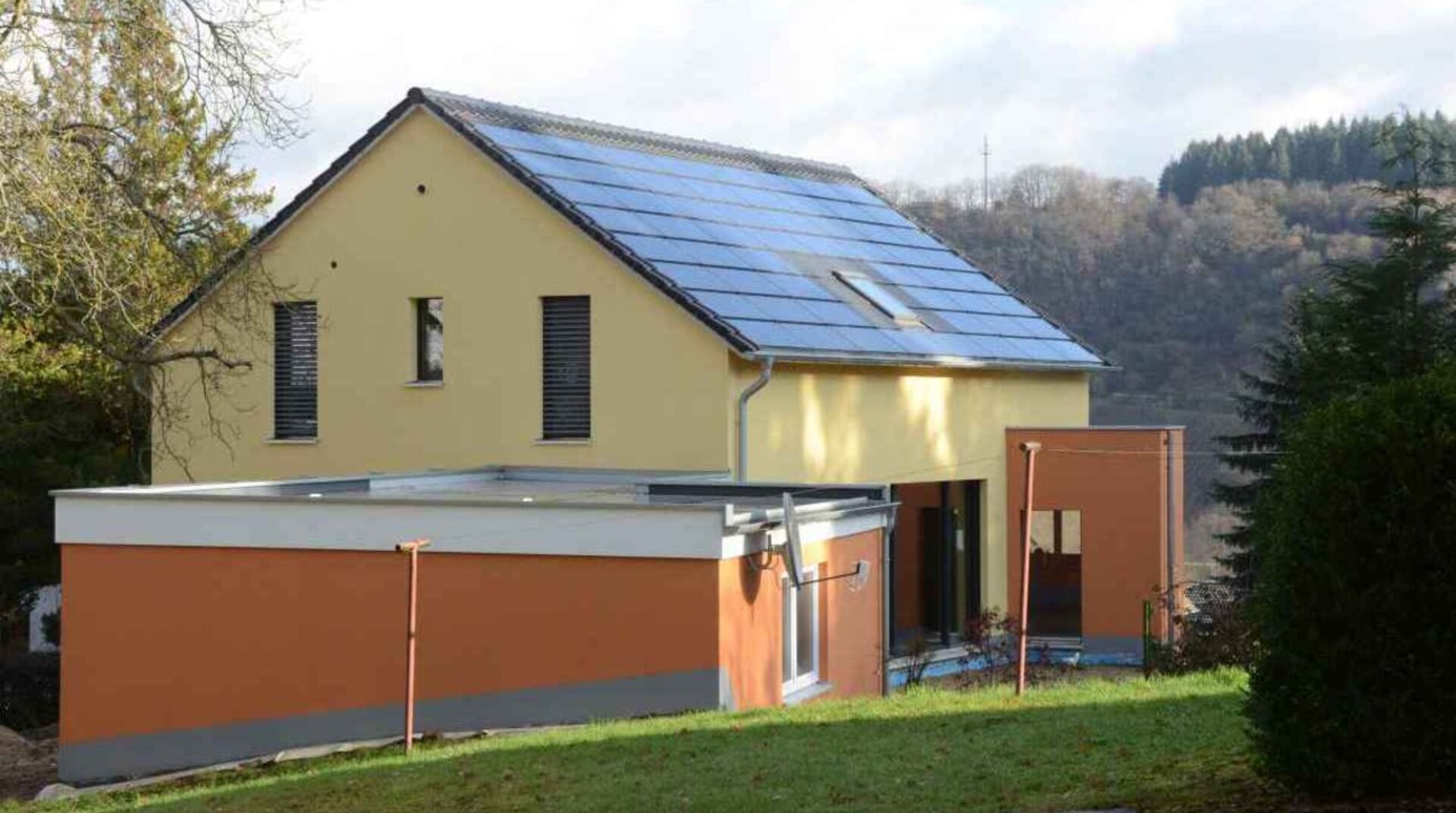 Müllers Bau Einfamilienhaus Konz Könen, Sicht vom Garten auf das Haus, gelb und ockerfarben, Rückansicht