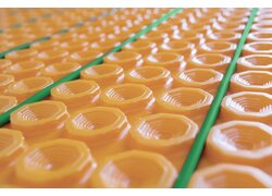 Orange Noppenplatte mit grünen Rohren.