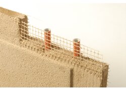 Lehmwand mit integrierten Heizungsrohren und Armierungsgewebe.